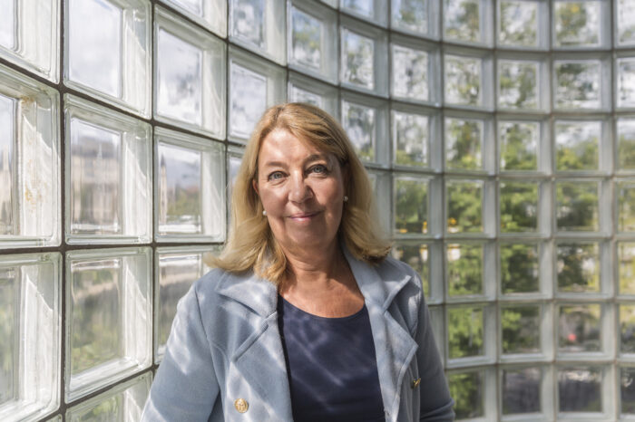 Annika Creutzer, ekonomijournalist och ekonomiexpert står framför en fönstervägg.-